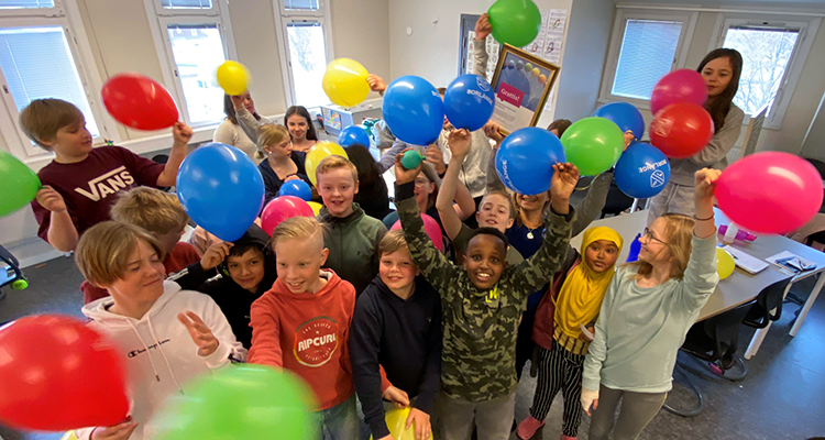 Glada barn viftar med ballonger