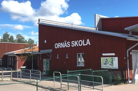 Faluröd byggnad med texten Ornässkolan på. 