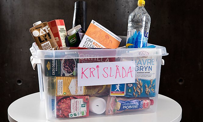 En plastlåda med texten krislåda. Lådan innehåller matvaror. Foto.