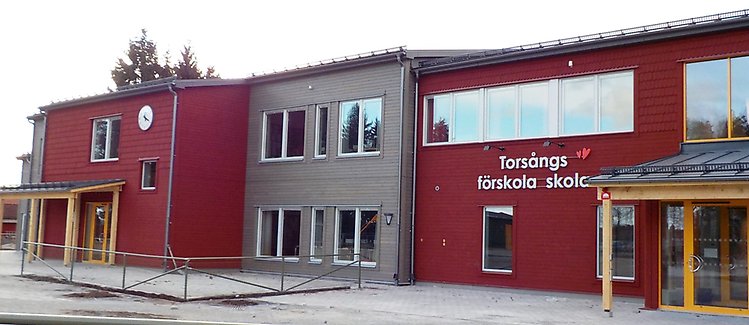 Röd och grå byggnad med texten Torsångs förskola skola