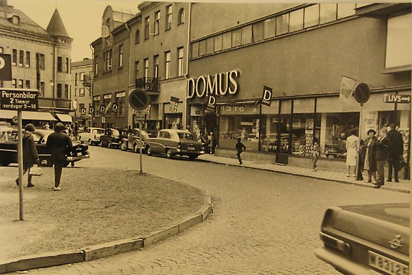 Historisk bild från Sveatorget i Borlänge, med Domus-skylt på fasad.